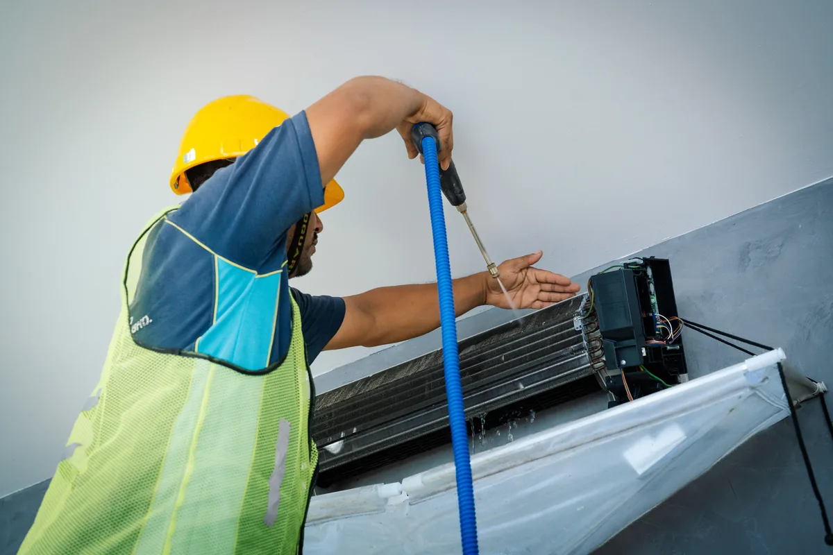 A wall-mounted split unit, its coil being washed.