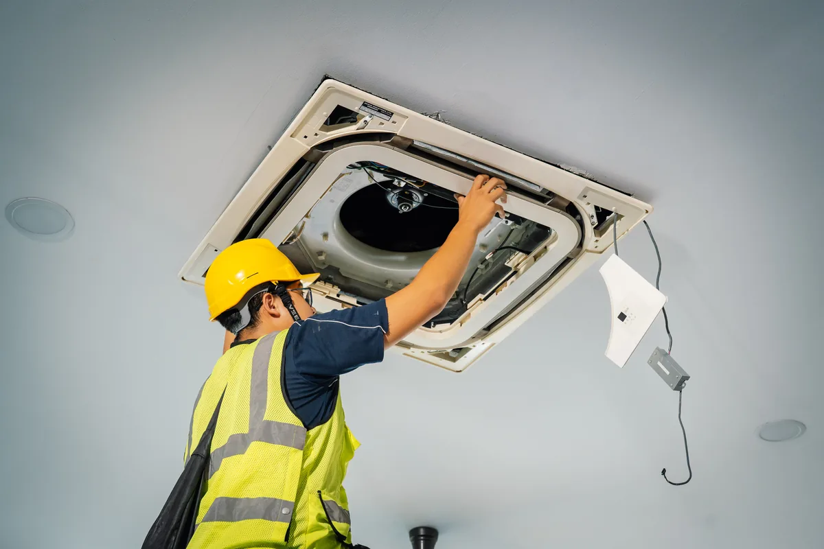 A ceiling cassette unit, its panel opened for servicing.